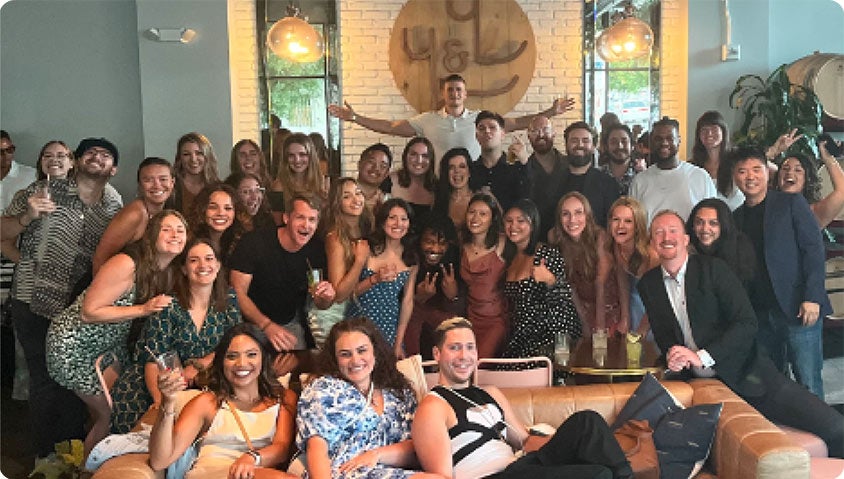 A group of over thirty Community Boost employees smiling at the camera.