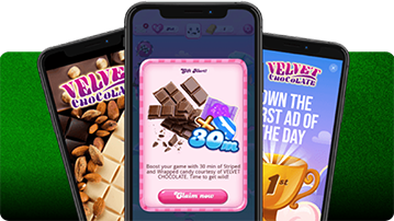 Drei Smartphones mit Candy Crush und Velvet-Chocolate-Werbung vor grünem Hintergrund.