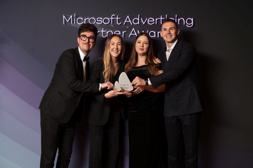 A photograph of four professionally dressed individuals posing together at the Microsoft Advertising Partner Awards.