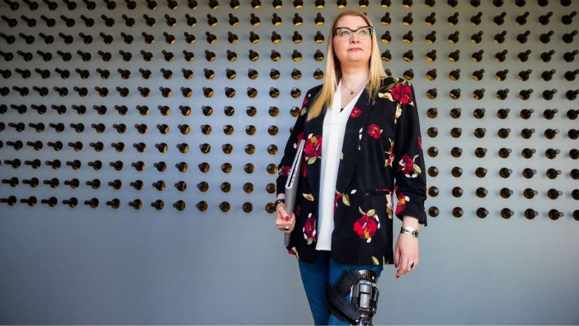 Portrait of tech industry employee with a mobile disability standing in U.S. office.